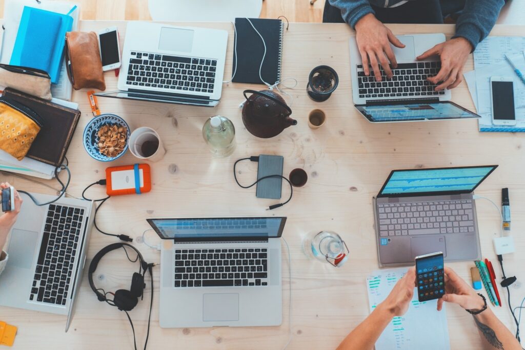 Overhead shot of computers at a work station with hands typing.